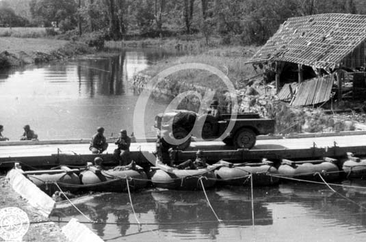 BRICQUEBEC(50260) Seconde guerre mondiale Un camion amricain roule sur un pont, des ingnieurs sont assis dans des bateaux pneumatiques soutiens du pont prfabriqu.