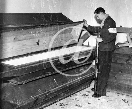 NATZWILLER(67130) Seconde guerre mondiale Dportation et Shoah - Camp de concentration de natzweiler - 17022005 Un FFI examine les cercueils entreposs en piles dans une dpendance.